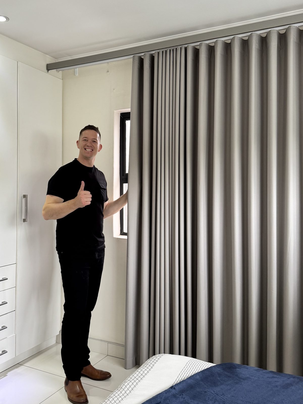 Grey blockout wave curtains professionally installed in a bedroom by Blind Concepts
